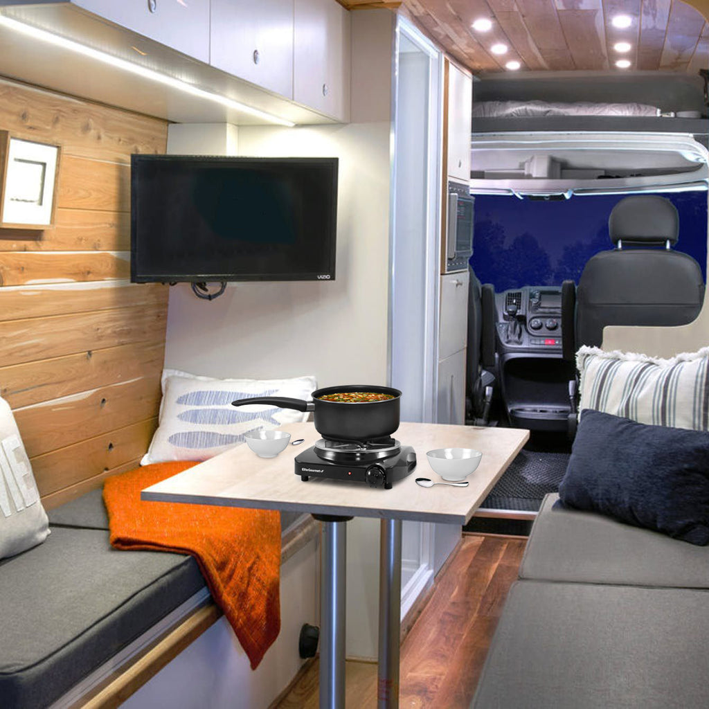 Burner being used inside a camper RV with soup in saucepan.