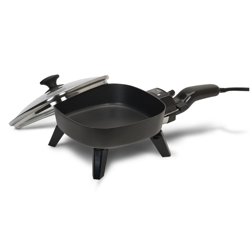 Empty mini skillet with glass lid set to side.