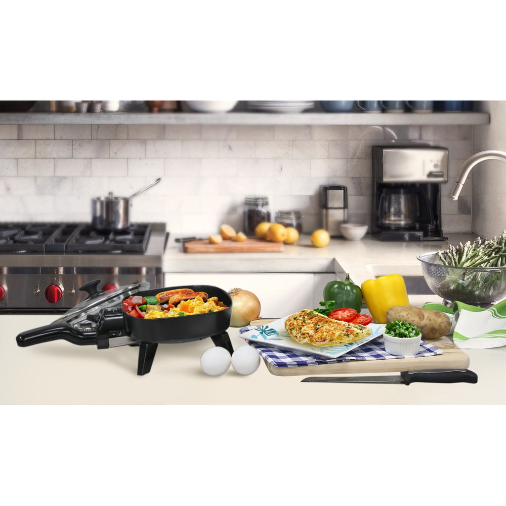 6-inch mini skillet on kitchen counter with scrambled eggs, omelet, and vegetables on cutting board.